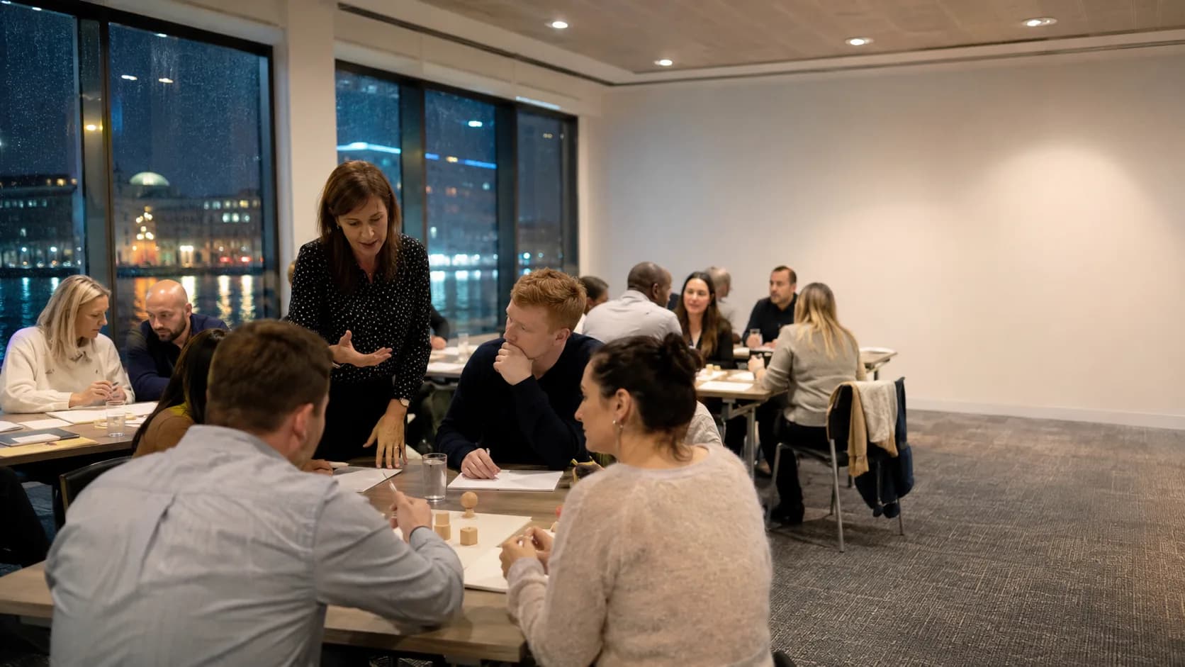 A facilitator leads an occupied training session around flexible tables