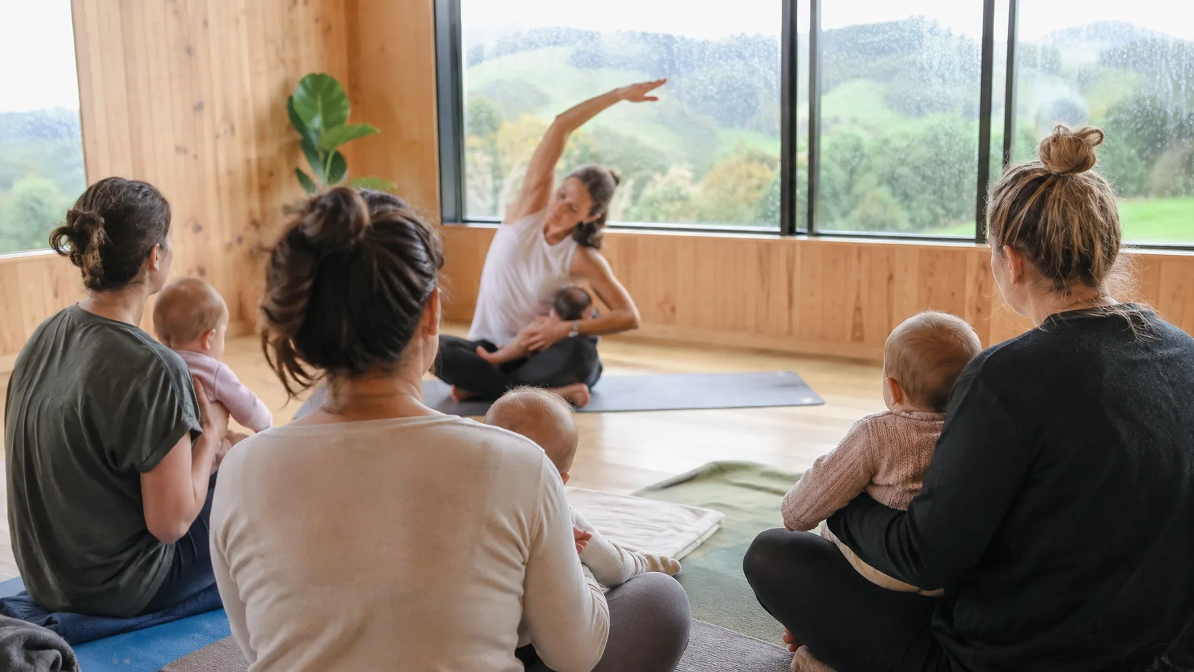 An class instructor leads a small parent-and-baby antenatal or parent-and-baby class in New Zealand