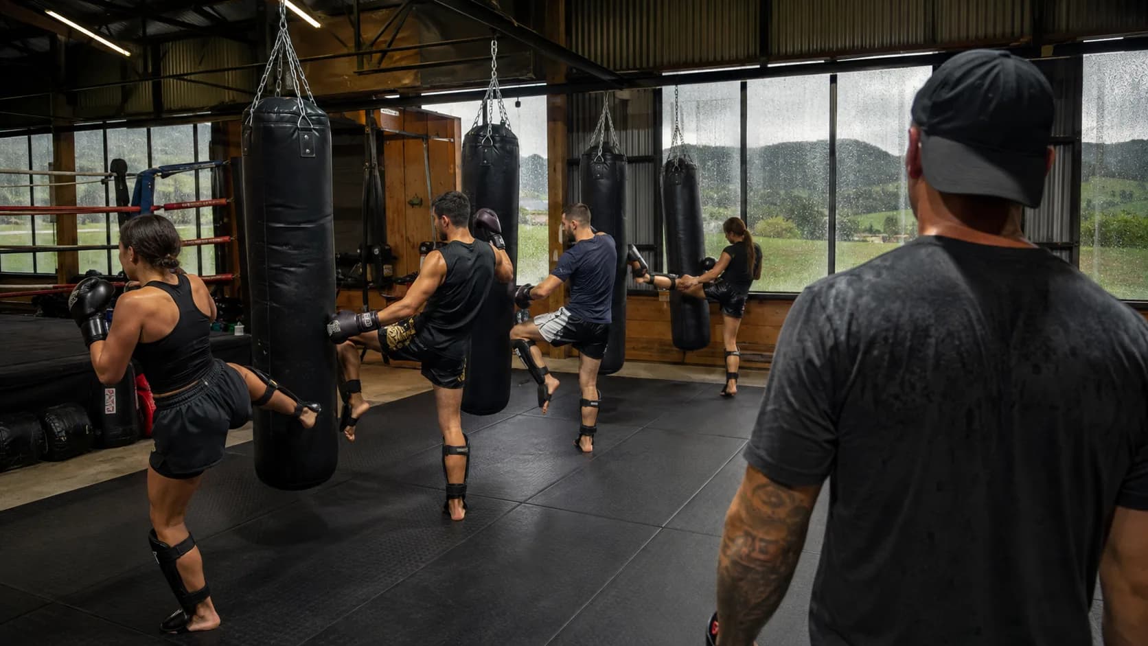 A boxing coach works the pads during an active gym class in New Zealand