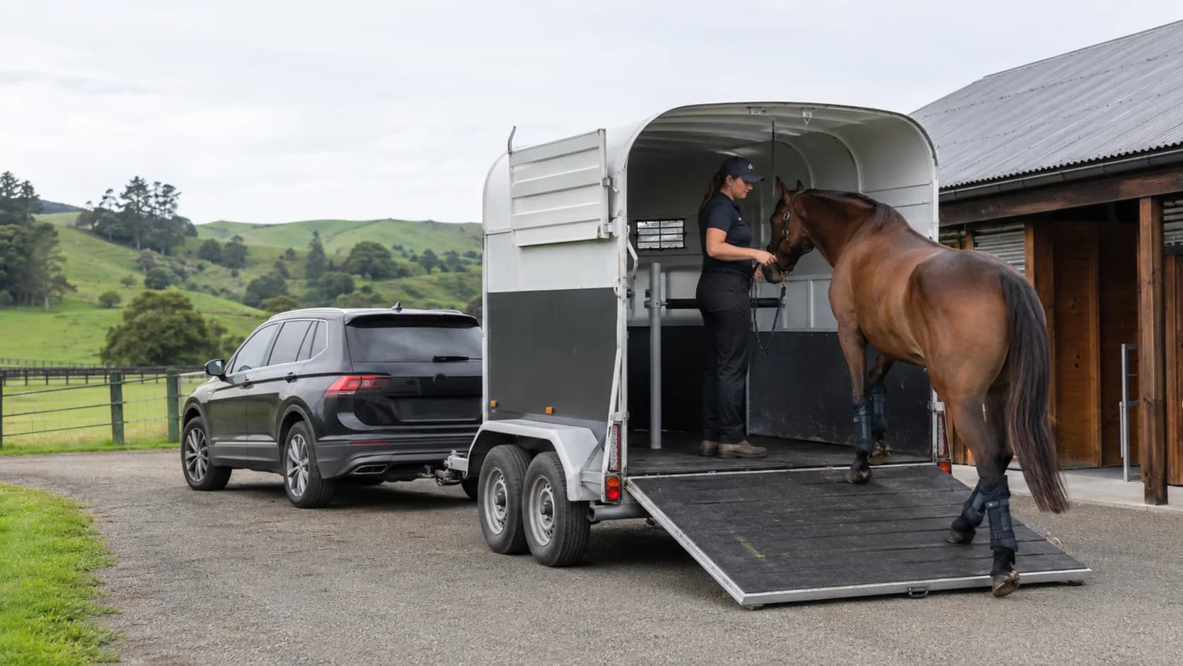 A float is loaded at a New Zealand grazing property with green hills behind