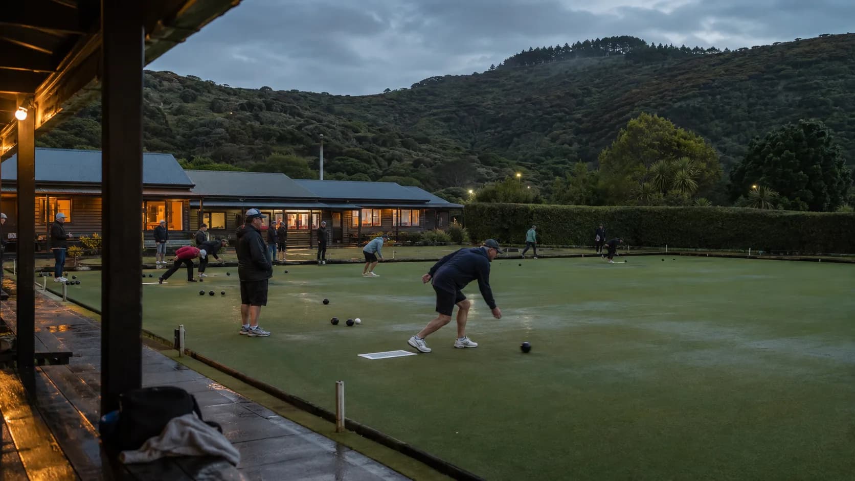 Club bowlers play beside a timber pavilion in New Zealand