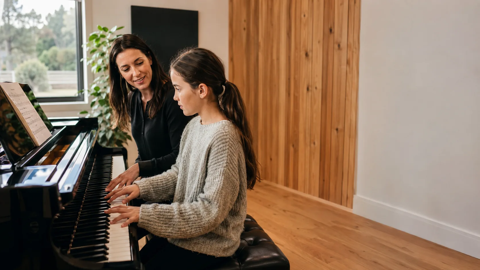 Piano tutor teaching a child inside a New Zealand timber studio