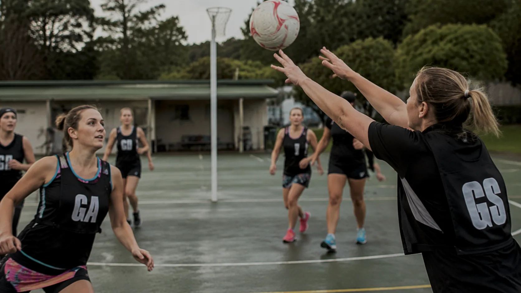 Netball courts at a New Zealand community centre, marked out and lit for evening club training