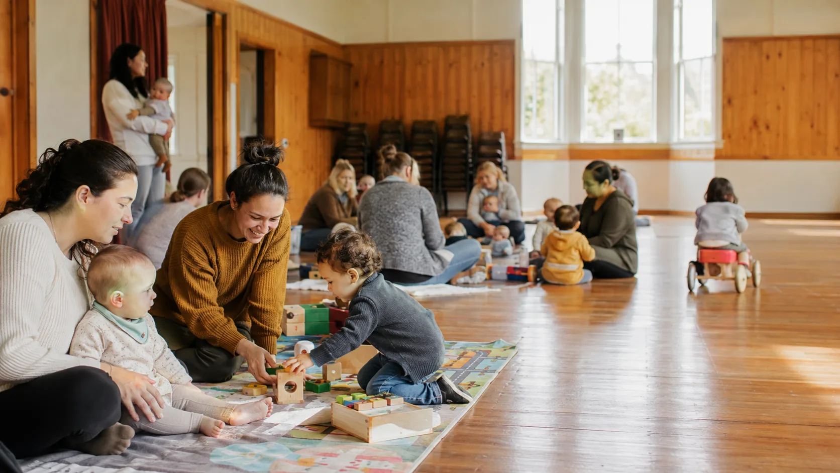 Families enjoying a playgroup session inside a New Zealand community hall