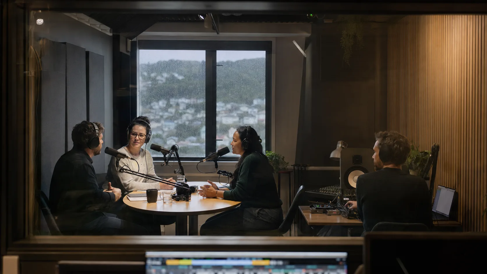 A host interviews a guest inside a bright New Zealand podcast studio