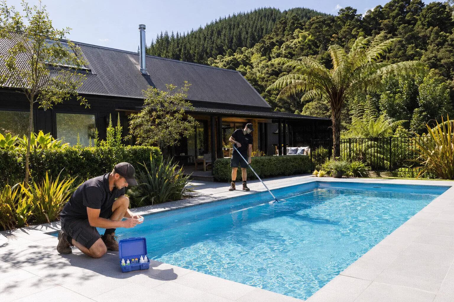 A pool technician testing the water at a backyard pool in New Zealand