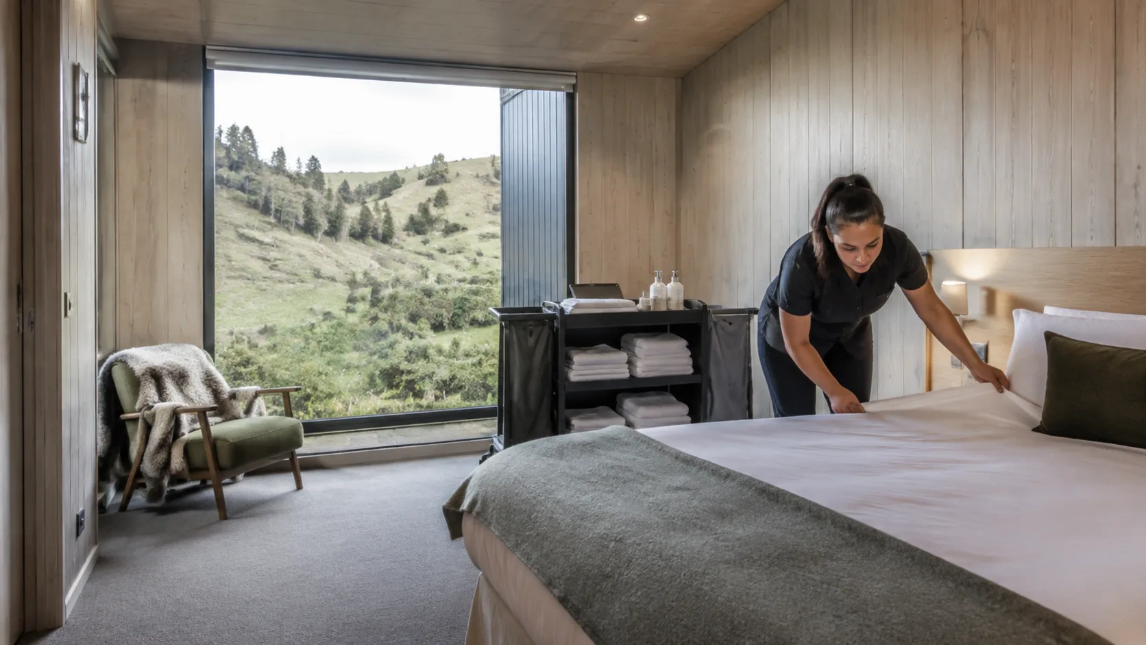 A turnover cleaner making up a bed in a short-stay property in New Zealand