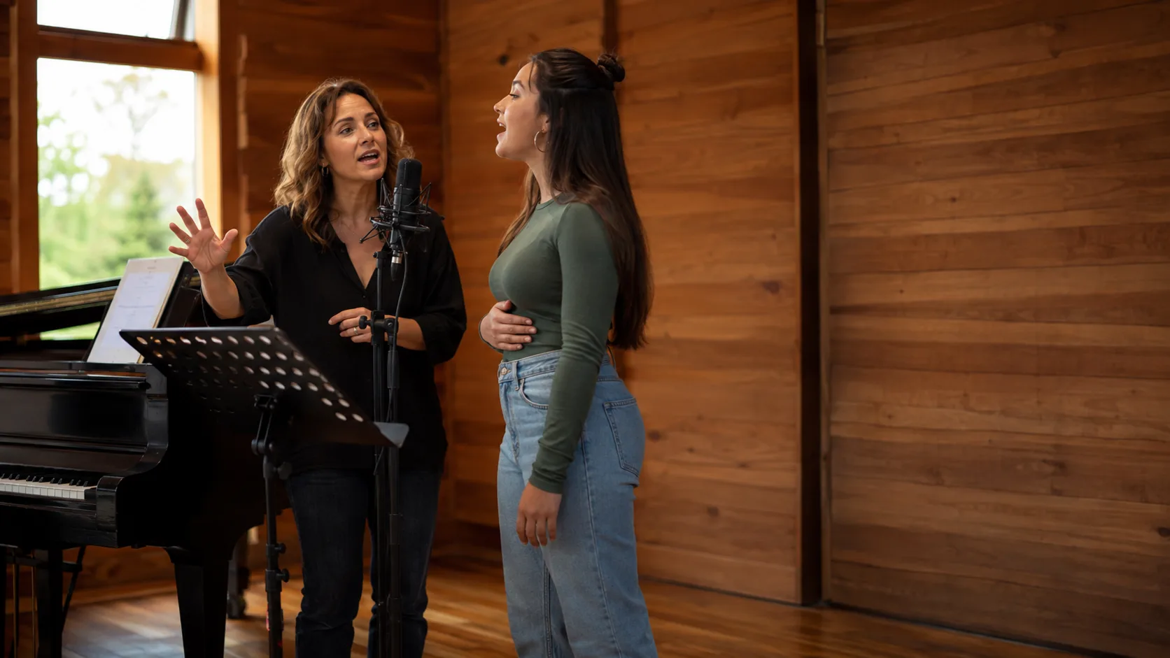 Vocal tutor guiding a student inside a timber studio in New Zealand