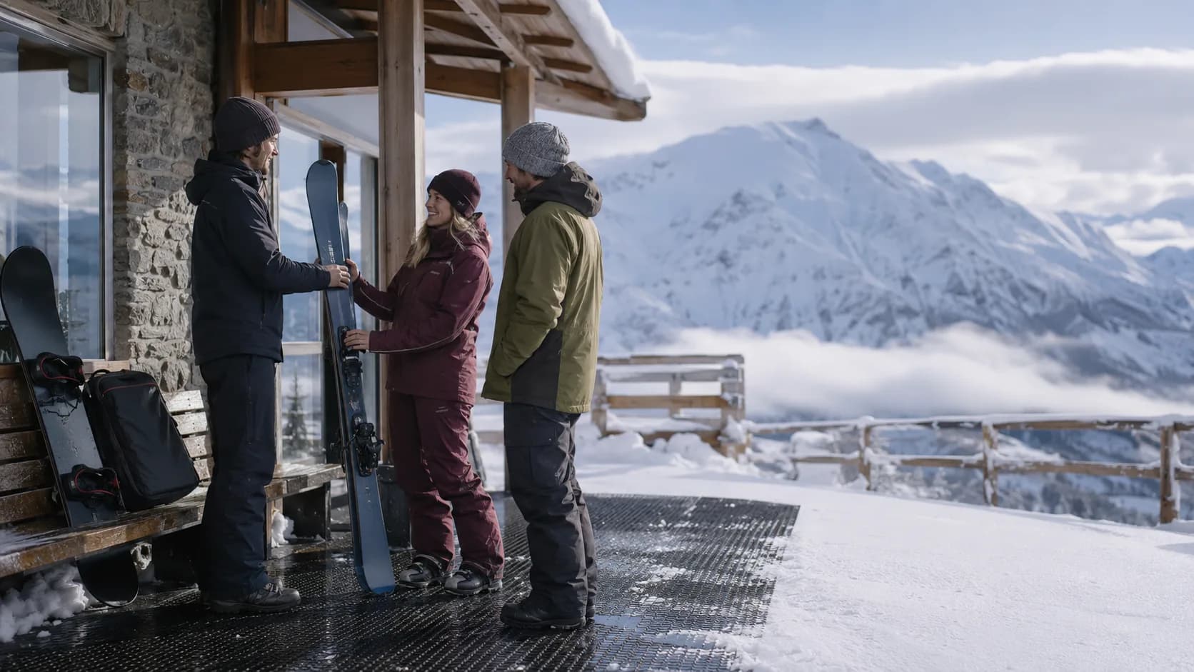 Operator preparing skis beside a snowy New Zealand rental lodge