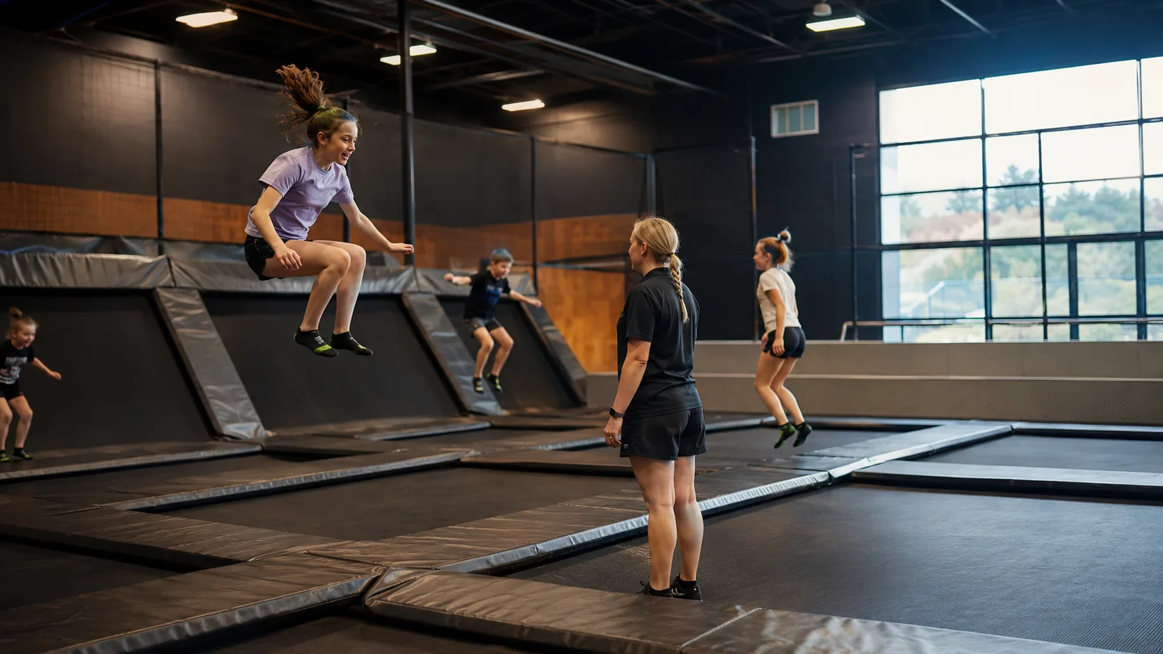 Children bounce across an indoor trampoline park floor in New Zealand
