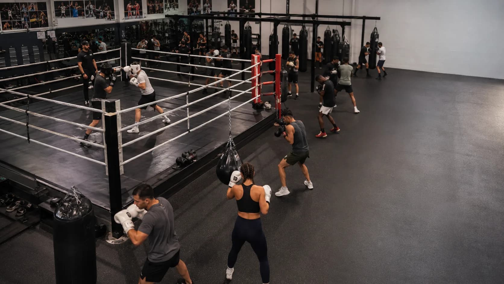 Boxers train around a busy commercial gym ring in the US