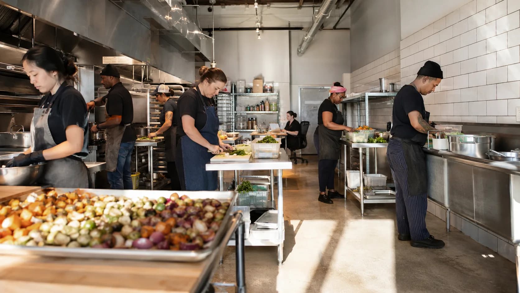 Food producers work across a busy shared kitchen during preparation
