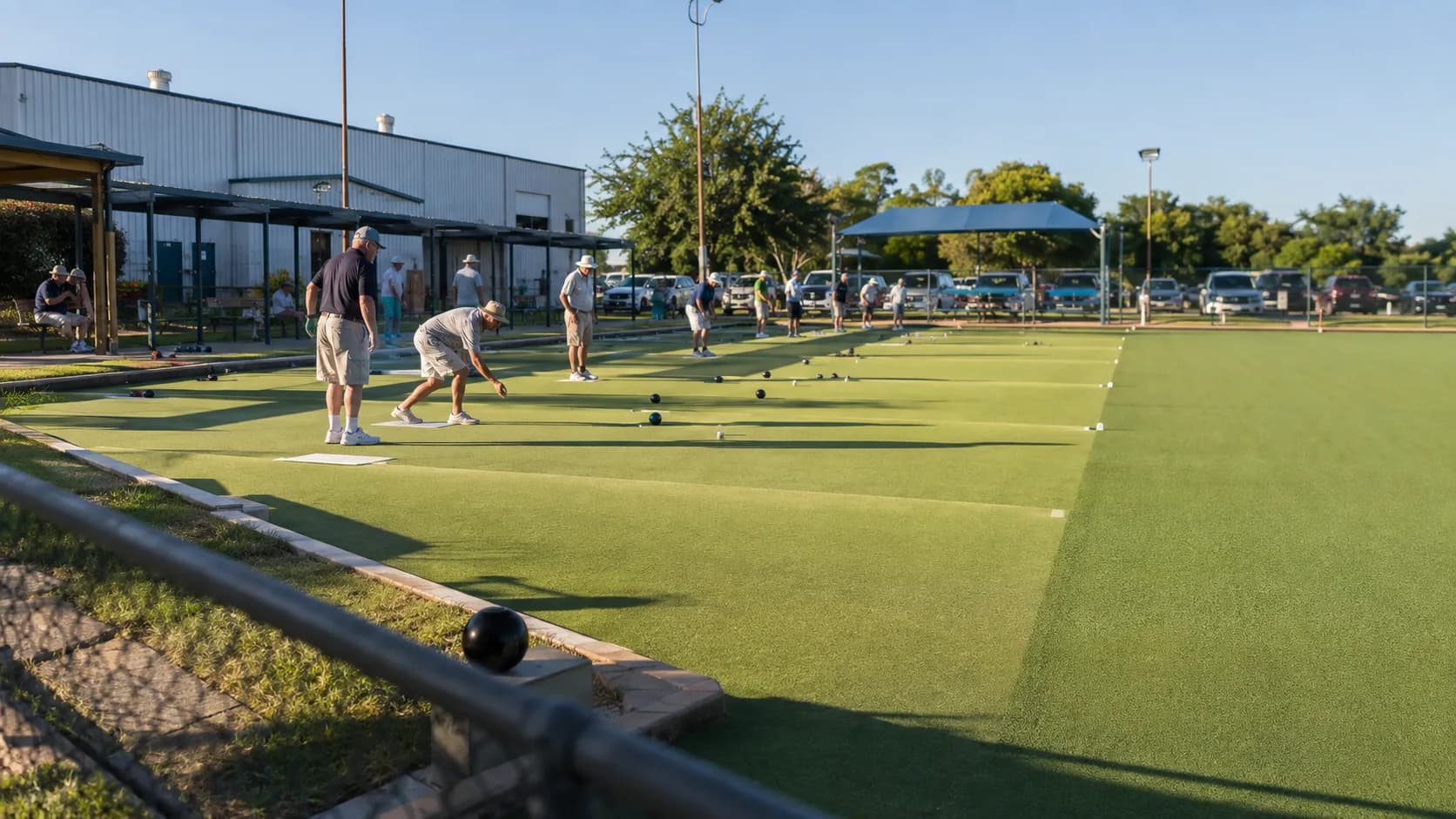 Mixed groups play lawn bowling beside a bright clubhouse in the US
