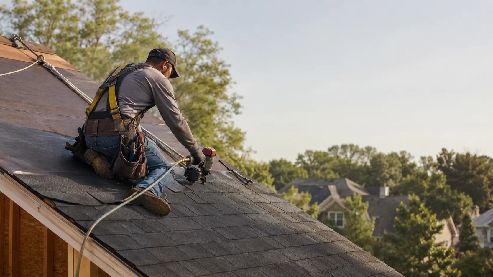 A roofer at work on a house roof in the US