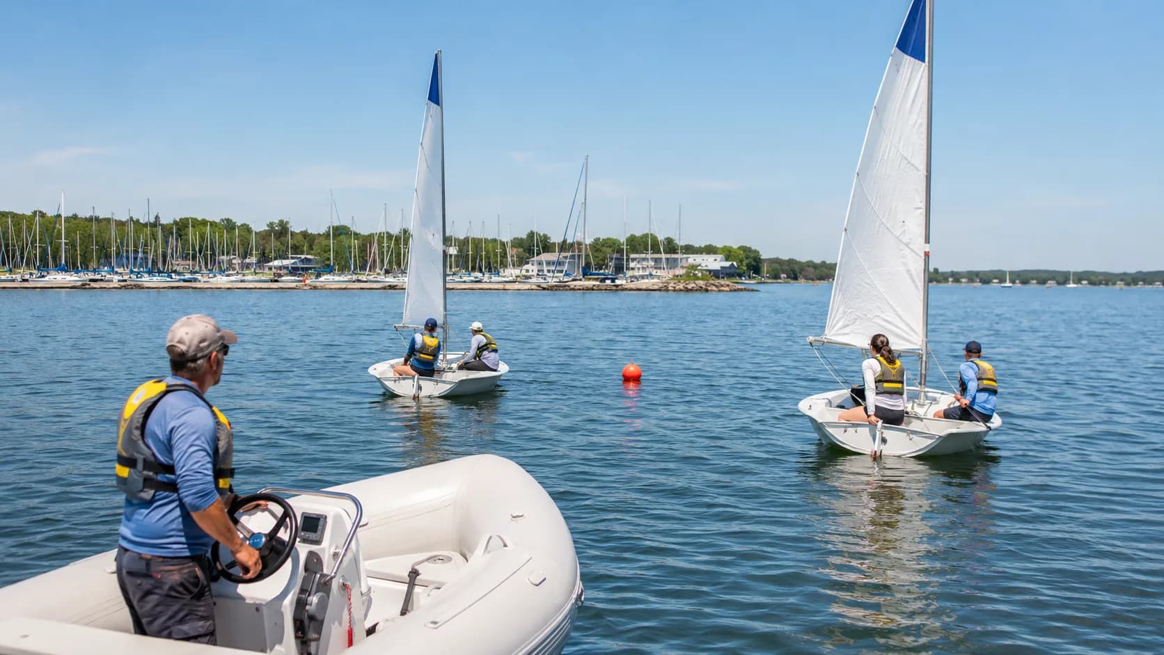 For sailing courses, beginner dinghy sailors practise turning drills on a lake in the US