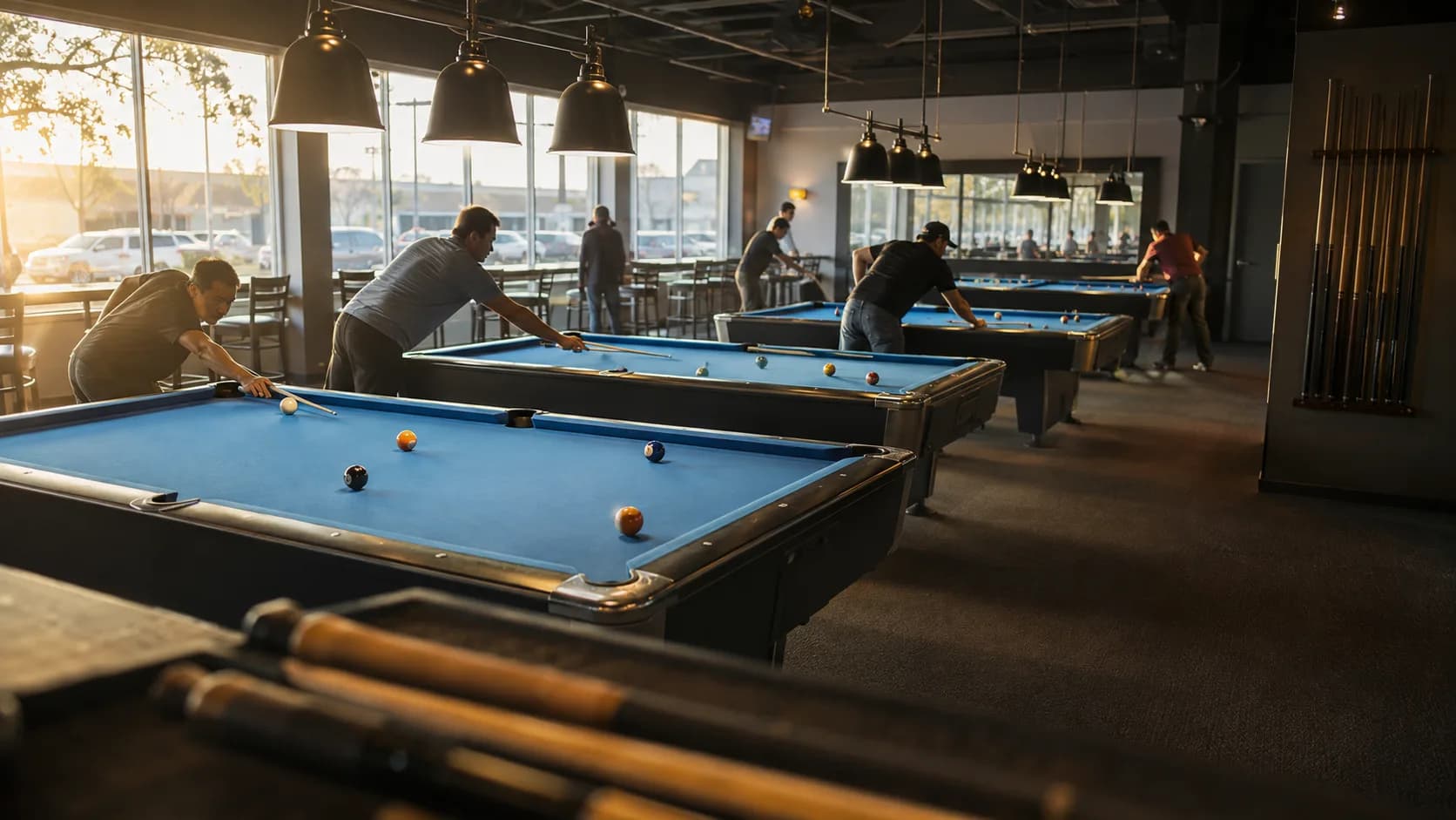 Groups play pool across a bright commercial billiards hall in the US