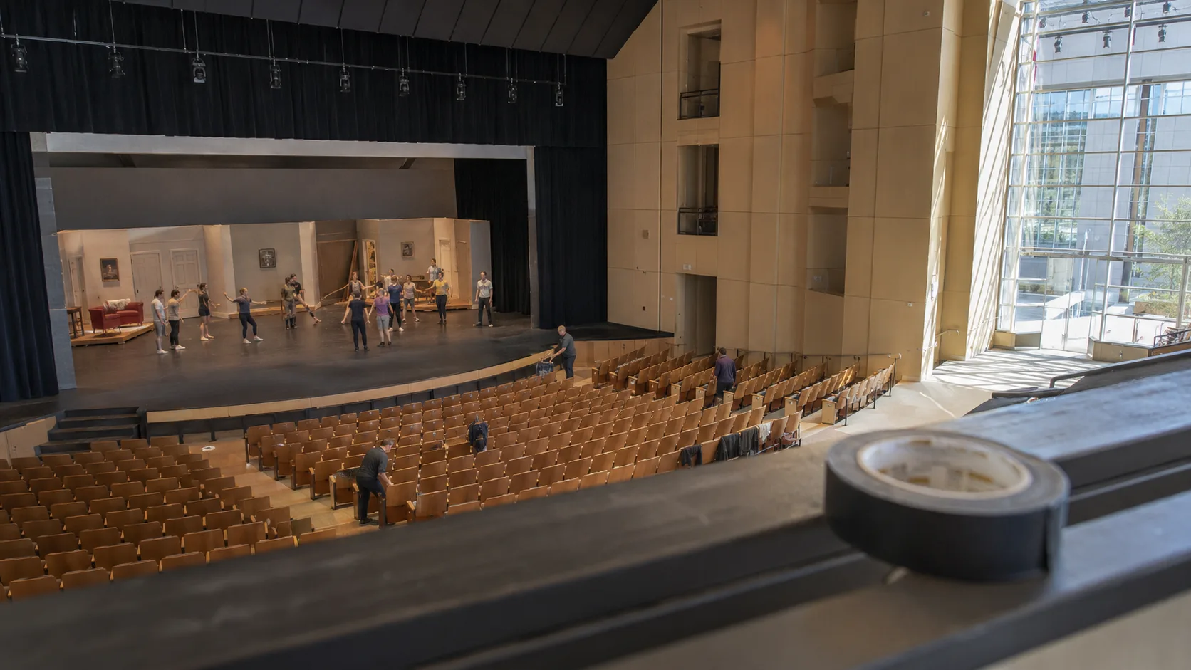 A technician checks a sunlit auditorium before a community performance
