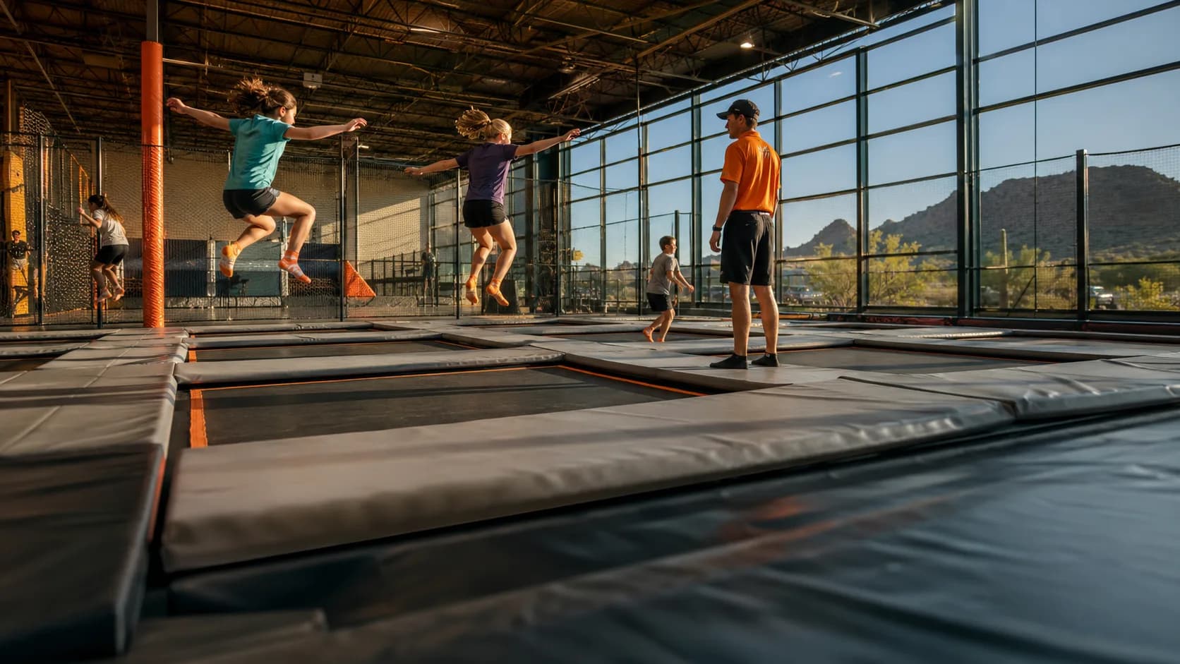 Kids bounce across a busy indoor trampoline park court in the US