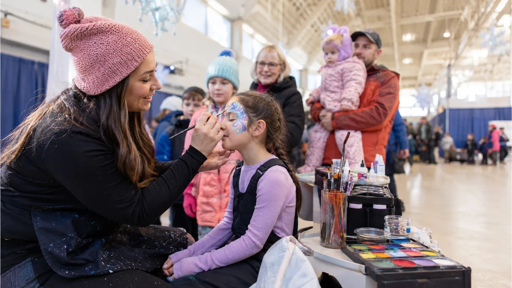 Face painter working at a busy family event in Canada