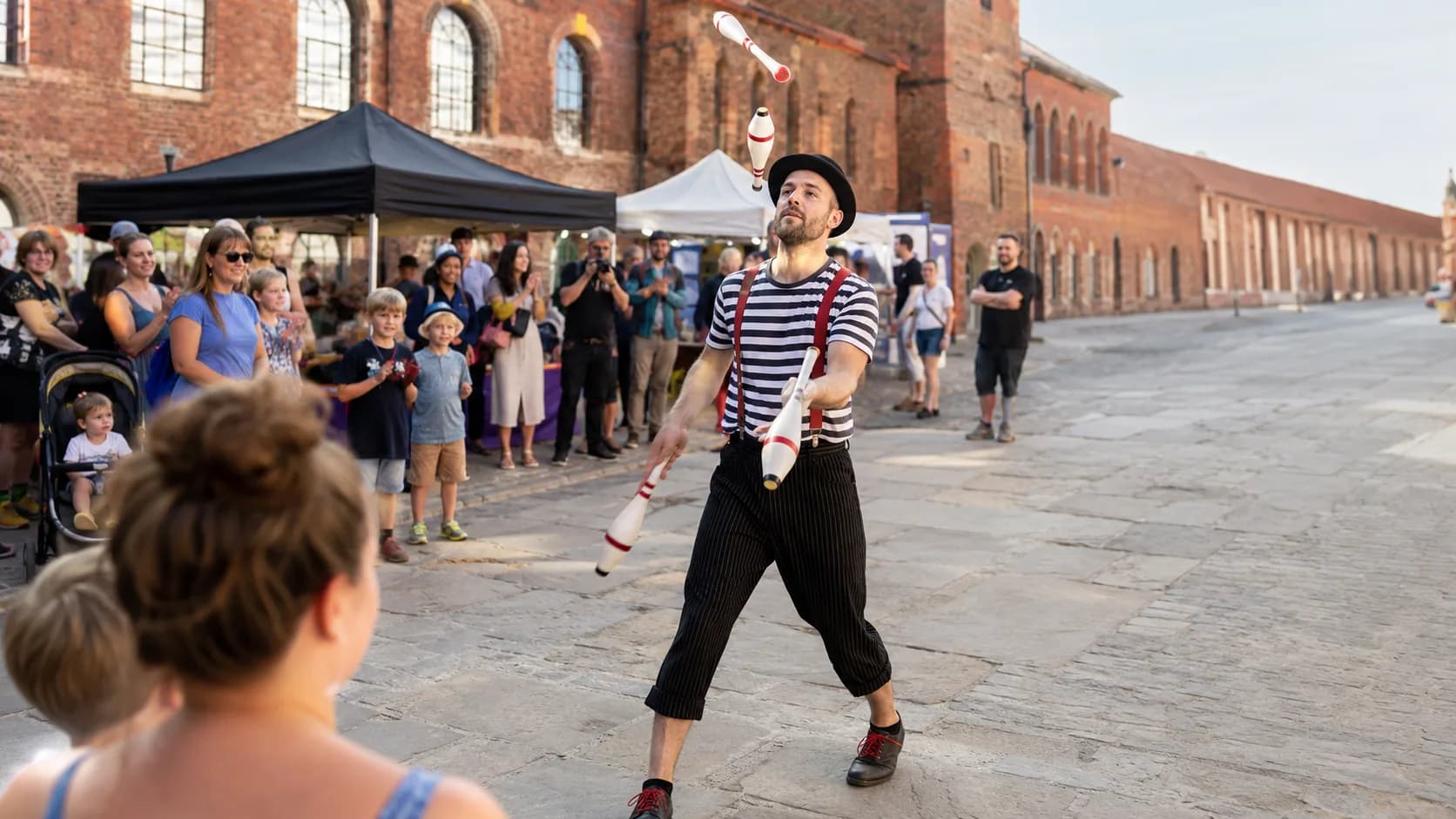 Roving circus performers entertaining a busy event crowd in the UK