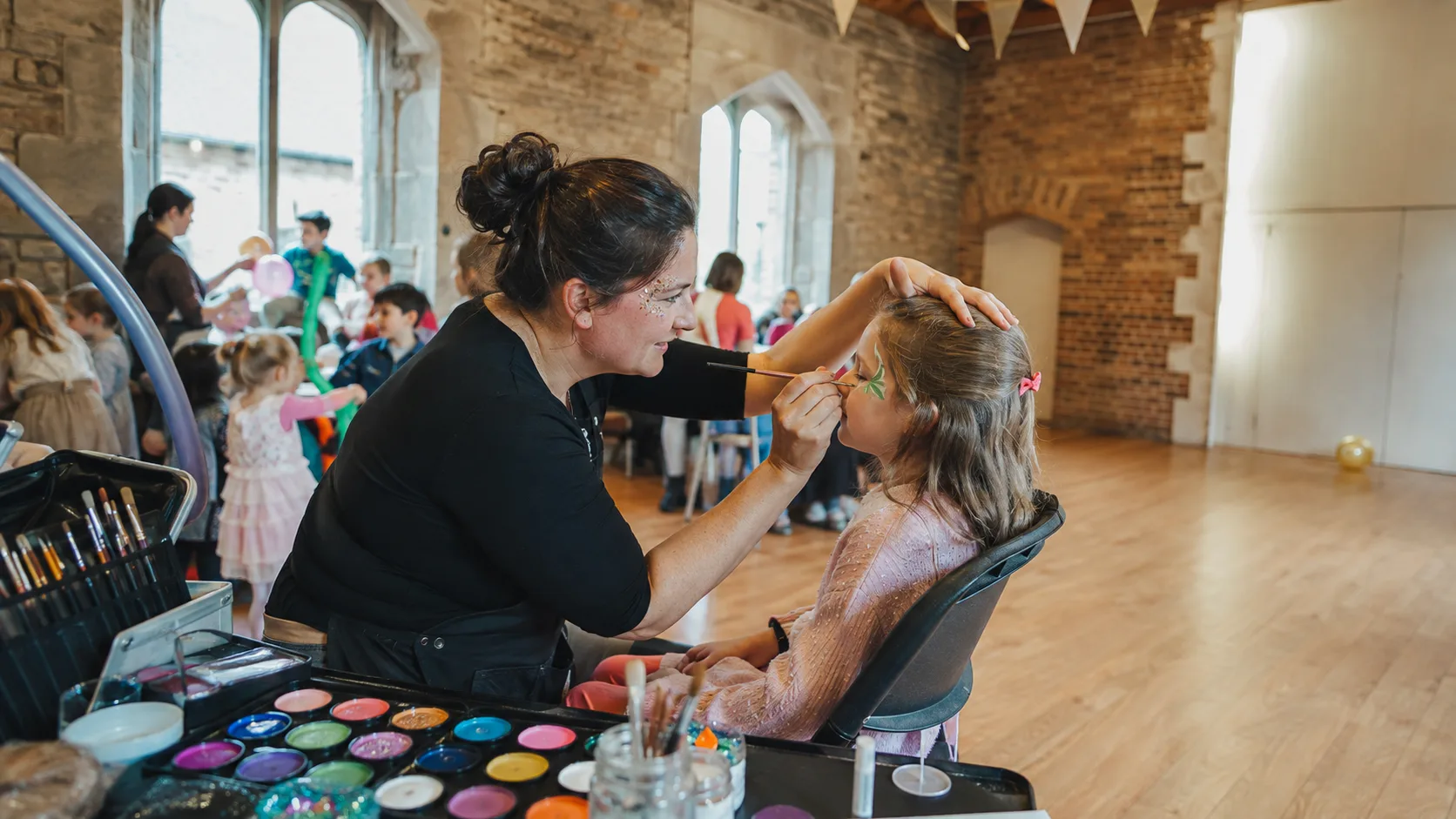 Face painter working at a busy family event in the UK